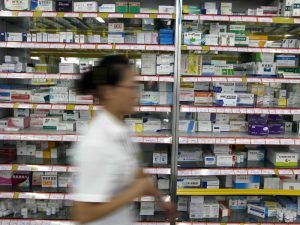 photo-of-a-pharmarcist-walking-past-shelves-with-medication-in-yucheng-northern-china